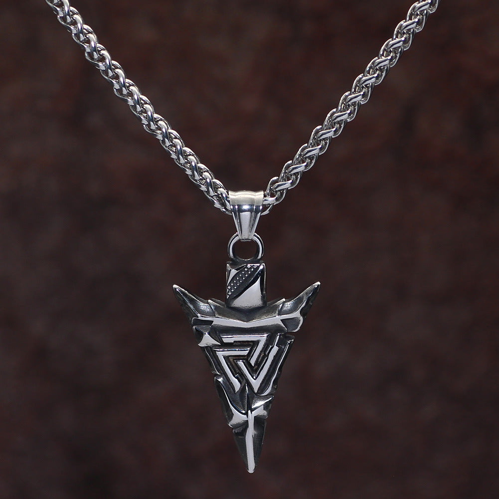Silver necklace with a detailed pendant on a dark brown background