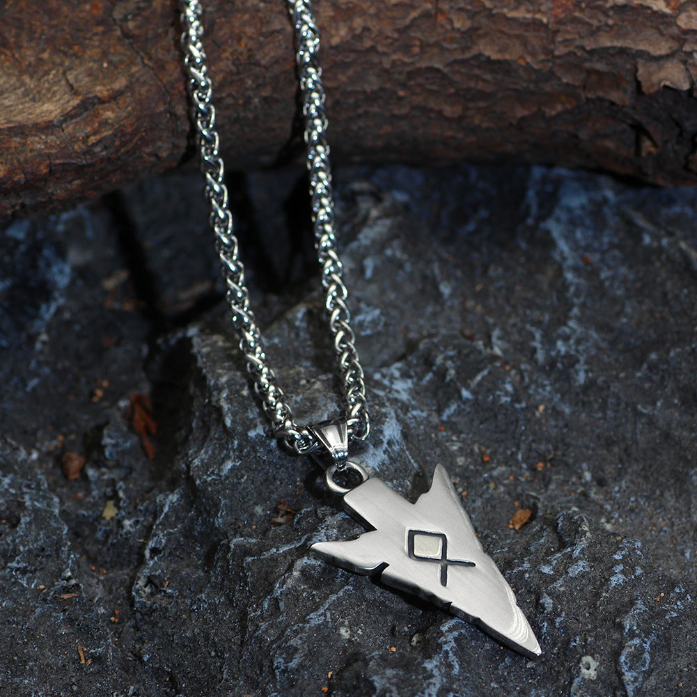 Silver necklace with a pendant on a textured stone surface