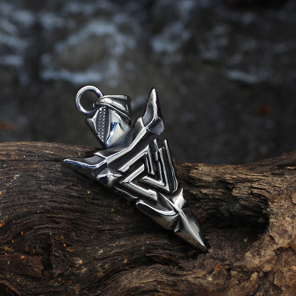 Silver pendant on a wooden surface with a blurred natural background