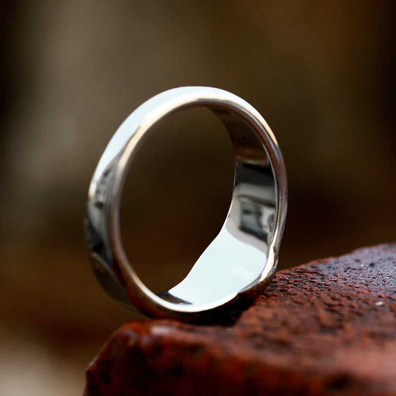 Silver ring on a textured brown surface with a blurred background