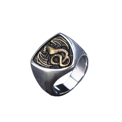 Silver ring with gold dragon design on a white background
