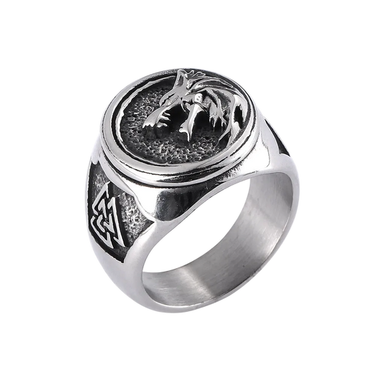 Silver ring with wolf design on a white background