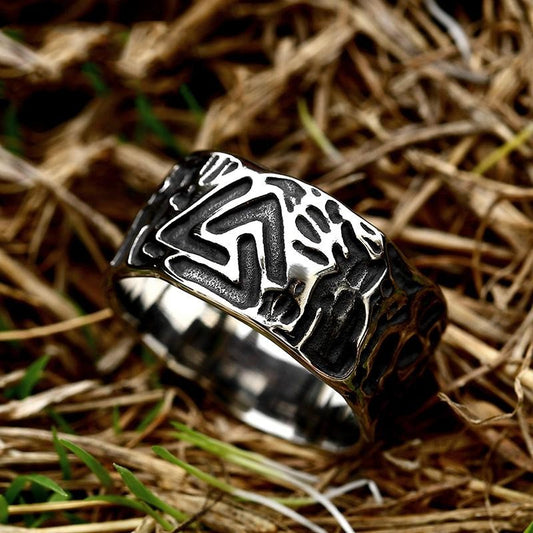Silver ring with intricate design on a grassy background