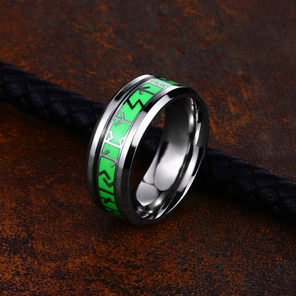 Silver ring with green inlay on a textured brown surface