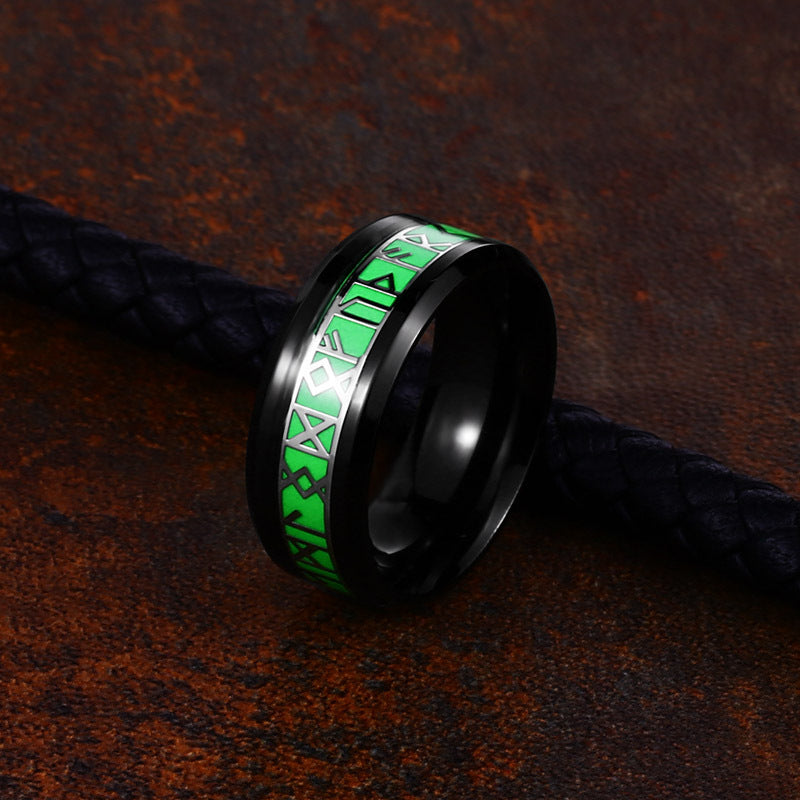 Black ring with green and white pattern on a dark textured background