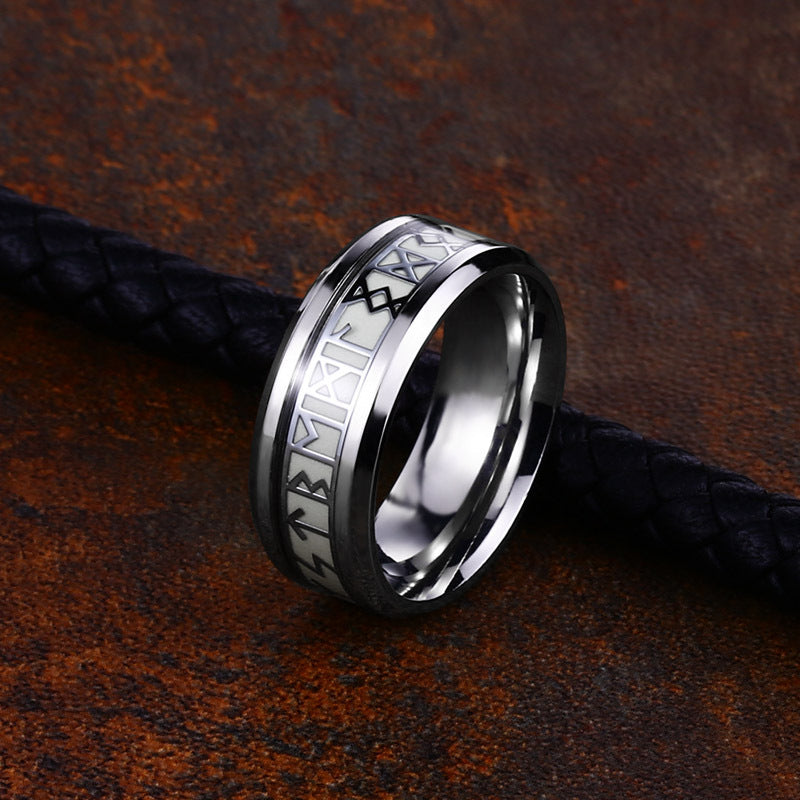 Silver ring with engraved design on a textured brown surface
